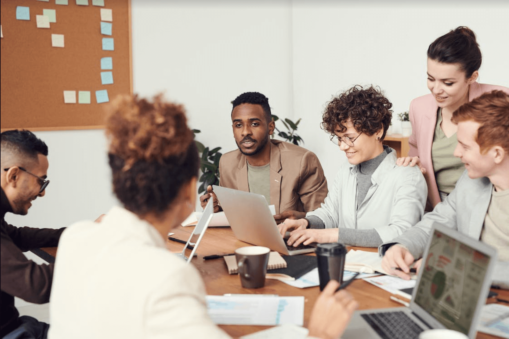 people in a meeting room on laptops